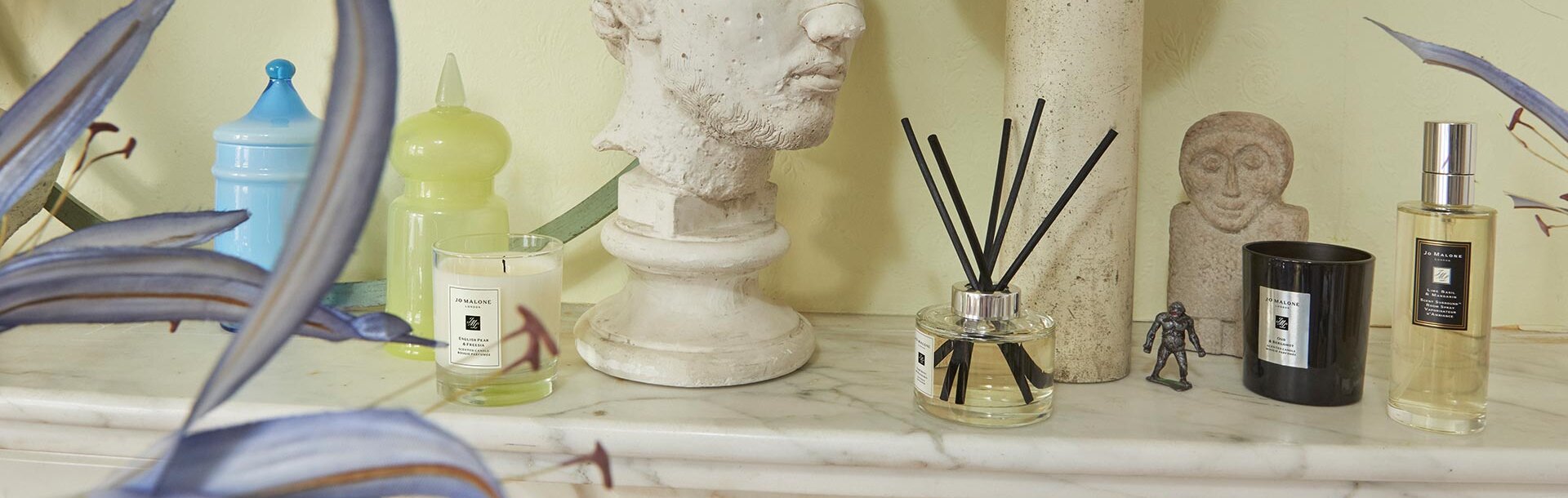 image of mantlepiece with Jo Malone travel candle, diffuser, candle & room spray in a range of scents alongside a bust