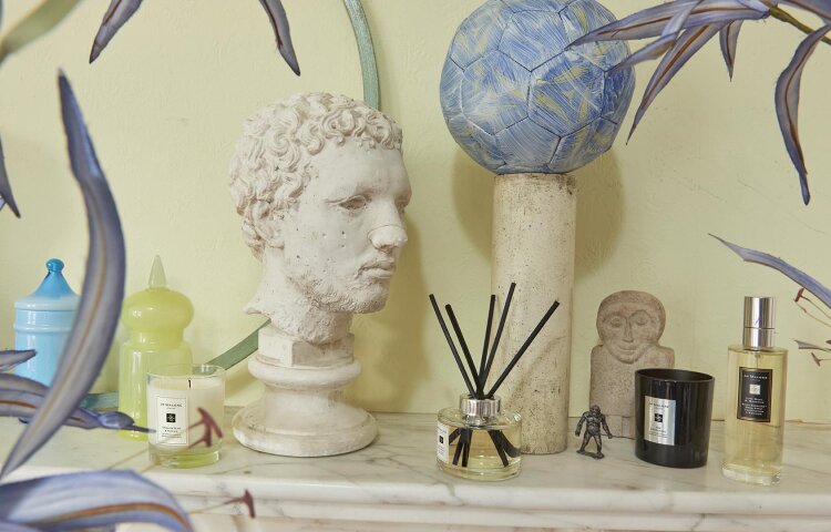 image of mantlepiece with Jo Malone travel candle, diffuser, candle & room spray in a range of scents alongside a bust